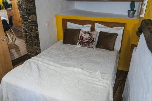 CandalMontanhas do Xisto - Casa da Parreira的卧室里有一张床，床单和枕头都是白色的