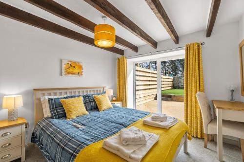 1 dormitorio con cama, escritorio y ventana en Arrowan Common Farm Cottages en Coverack