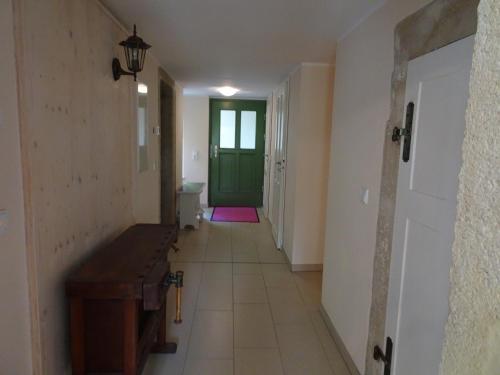 un couloir vide avec une porte verte et une chambre dans l'établissement Das Gäste Haus, à Dresde