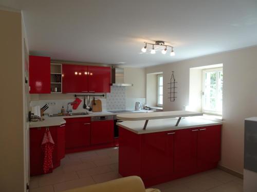 a kitchen with red cabinets and a white counter top at Das Gäste Haus in Dresden