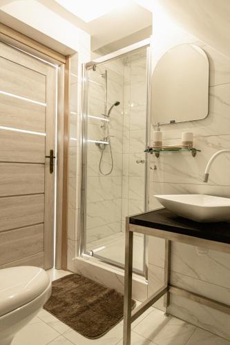 a white bathroom with a sink and a shower at Przystanek Kozia Góra in Kozia Góra