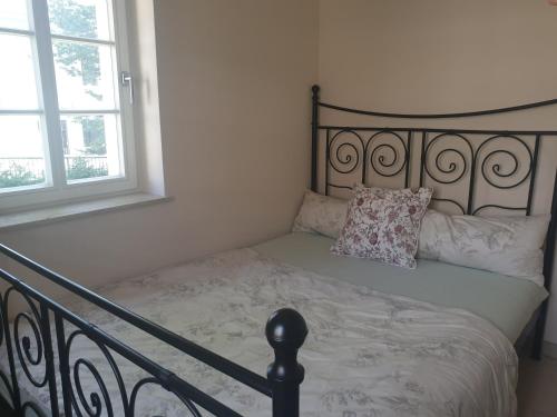 a bed with a black frame and a pillow on it at Das Gäste Haus in Dresden