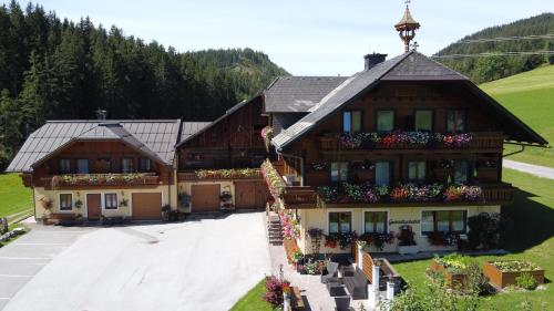 an aerial view of a building with flowers on the windows at Pension-Greimelbacherhof in Ramsau am Dachstein