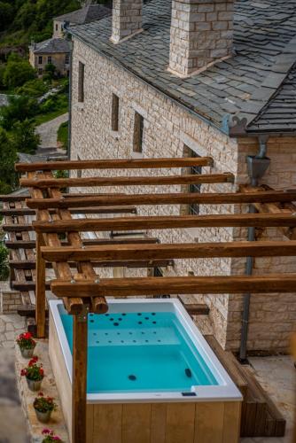 an outdoor swimming pool with a wooden deck and a swimming pool at Pirrion Wellness Boutique Hotel in Ano Pedina