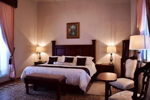 a hotel room with a bed and a chair at Hotel Boutique La Albertina in San Martín Texmelucan de Labastida