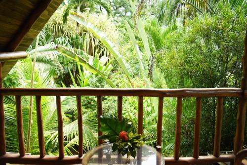 a vase with a flower sitting on a balcony at Pachamama Tropical Garden Lodge in Carmen