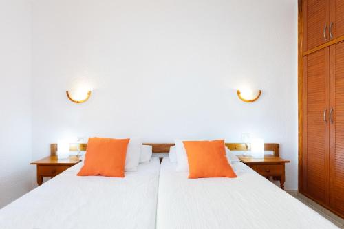 a bedroom with two beds with orange pillows at LOS ANGELES Holiday Home in Los Cristianos