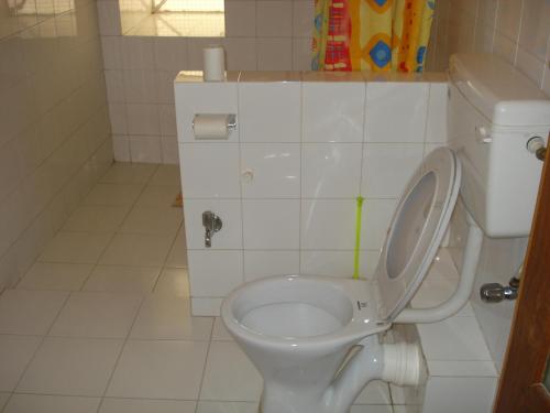 a bathroom with a toilet with the lid up at Haveli Braj Bhushanjee Heritage Hotel in Būndi