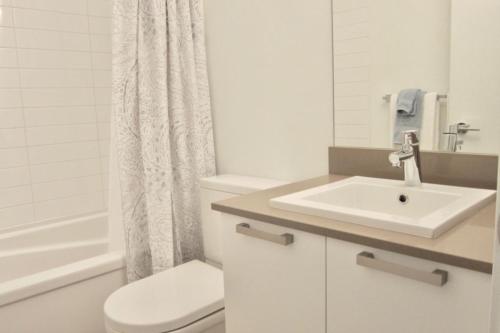 een witte badkamer met een wastafel en een toilet bij Lotus Loft in Victoria