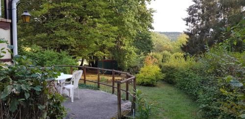 a table and chairs on a walkway in a garden at Le chalet du lac de chaumeçon au coeur du morvan in Saint-Martin-du-Puy
