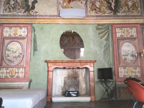 a living room with a fireplace and a tv at PALAZZO BECCAGUTTI CAVRIANI - Gallery Suite e Frescoes Suite in Mantova