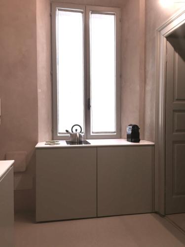 a kitchen with a sink and two windows at PALAZZO BECCAGUTTI CAVRIANI - Gallery Suite e Frescoes Suite in Mantova