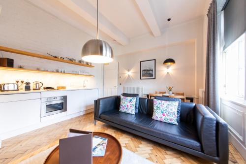 a living room with a black leather couch and a table at Linton Collection - 28 North Bridge in Edinburgh