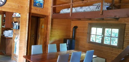 a dining room with a table and white chairs at Le chalet du lac de chaumeçon au coeur du morvan in Saint-Martin-du-Puy
