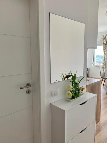 a room with a mirror and a white dresser at Blini Studio Apartment in Pristina