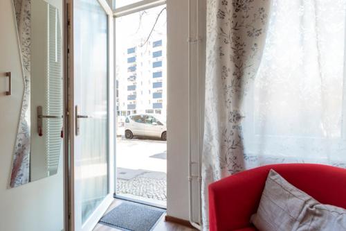 a red couch sitting in front of a sliding glass door at K&S Apartments in Berlin