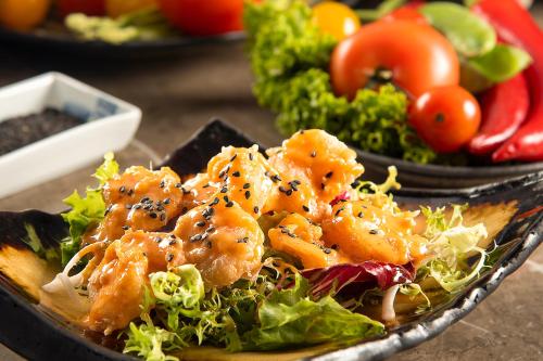 a plate of food with chicken and salad on a table at Ascott Rafal Olaya Riyadh in Riyadh