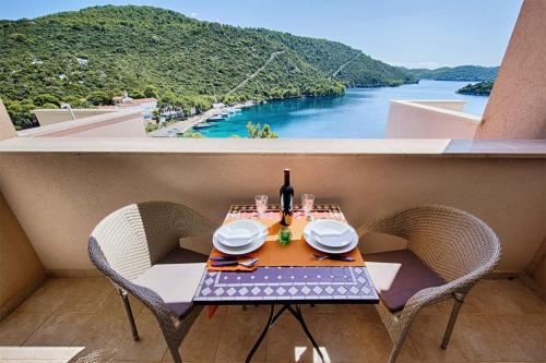 a table with a bottle of wine on a balcony at Apartments Ladesta in Lastovo
