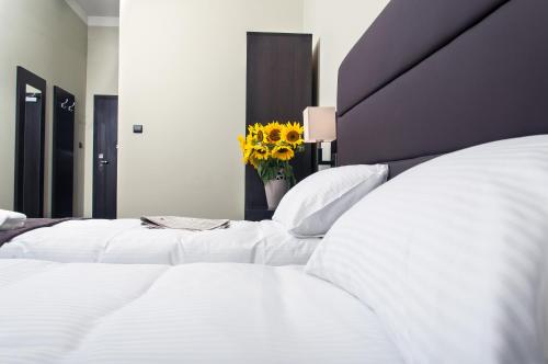 two white beds in a bedroom with a vase of flowers at Hotel Ilan in Lublin
