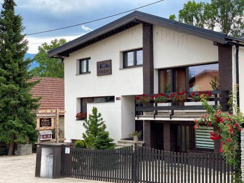 une maison blanche avec une clôture devant elle dans l'établissement Privat FoRest, à Liptovský Mikuláš