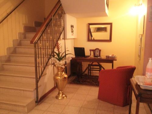 a staircase with a vase of flowers and a desk with a laptop at Affittacamere Centro Storico in Raiano