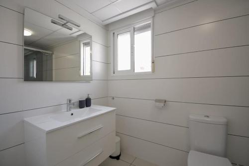 Un baño blanco con lavabo y espejo. en Hillasol vakantiewoning El Pinet Beach, en La Marina
