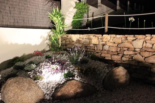 a garden with rocks and plants and a stone wall at Apartamentos Maritimo Suites-Solo Adultos in O Grove