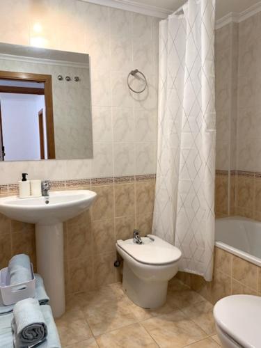 a bathroom with a sink and a toilet and a mirror at UIM Mediterraneo Diagonal 17 Wifi in Puerto de Sagunto