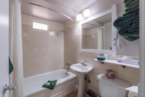 a bathroom with a sink and a tub and a toilet at Canada's Best Value Desert Inn & Suites in Cache Creek