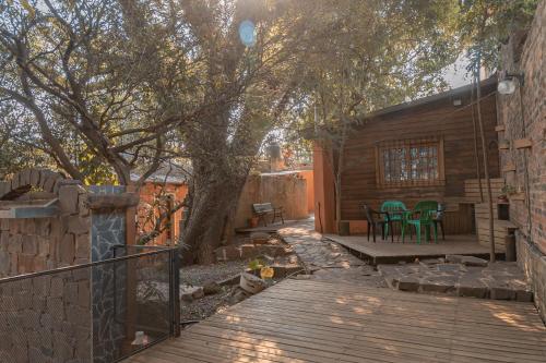 a wooden deck with a tree and a house at Descanso Verde in Oberá