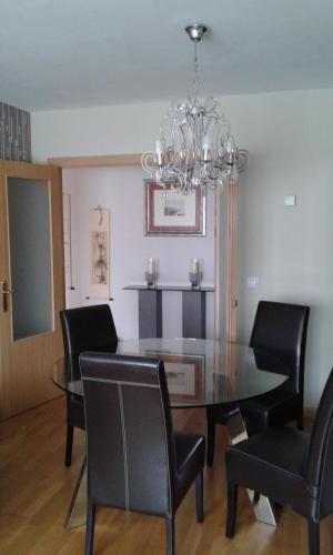 a dining room with a glass table and black chairs at PISO ALISAL CON GARAJE in Santander