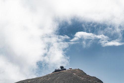 a lighthouse on top of a mountain under a cloudy sky at Wilcza For Rest in Karpacz