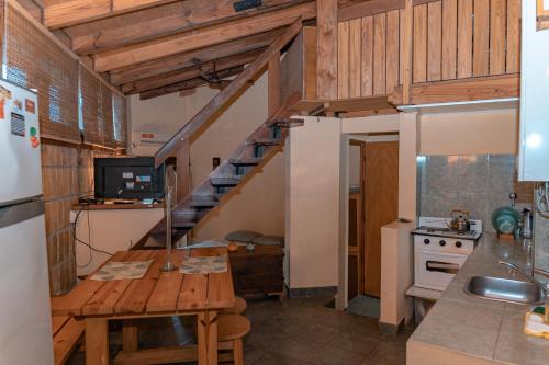 eine Küche mit einem Holztisch und einer Treppe in der Unterkunft Descanso Verde in Oberá