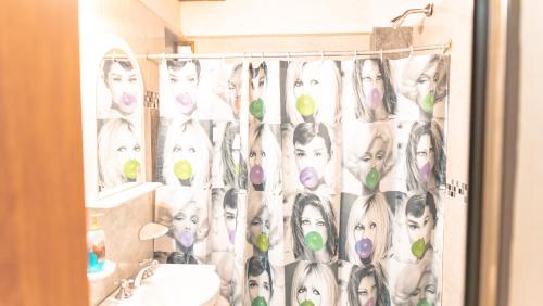 a bathroom with a shower curtain with drawings of women at Descanso Verde in Oberá