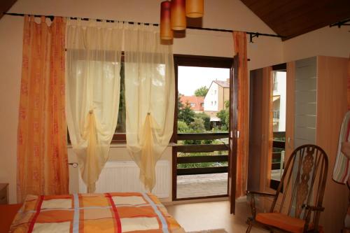 a bedroom with a bed and a large window at Ferienhaus Susanne in Haßloch