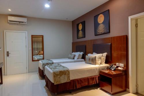 a bedroom with two beds and a telephone in it at Frederick's Lodge in Kumasi