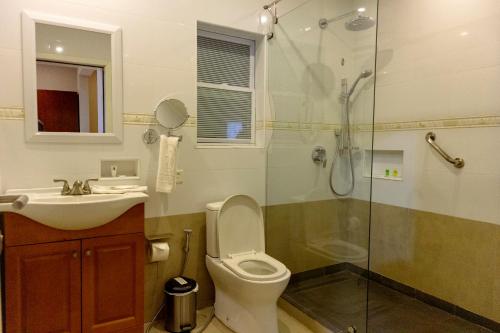 a bathroom with a toilet and a sink and a shower at Frederick's Lodge in Kumasi