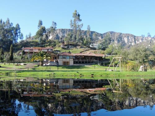 a house on a hill next to a lake at Killary Lodge in Cachanlo de Sidcay
