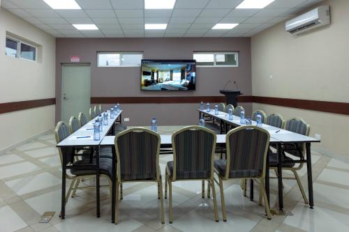 a conference room with a long table and chairs at Frederick's Lodge in Kumasi