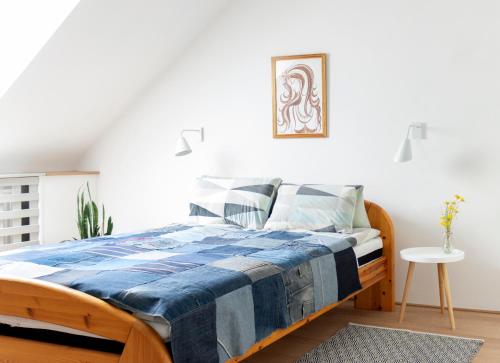 a bedroom with a bed with a blue and white blanket at Vár5 Apartman in Szigetvár