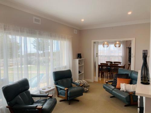 a living room with a couch and chairs and a table at Jewel of the South Beachfront Holiday Rental in Tumby Bay