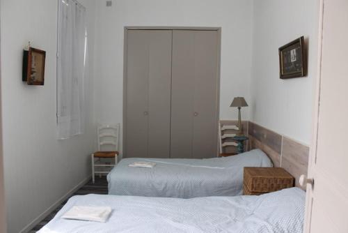 une chambre avec deux lits dans une pièce dans l'établissement maisonnette, 5003, à Rochefort