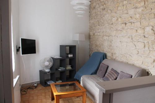 sala de estar con sofá y mesa en maisonnette, 5003, en Rochefort