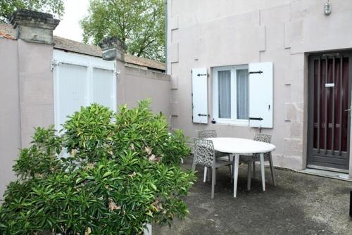 un patio con mesa y sillas junto a un edificio en maisonnette, 5003, en Rochefort