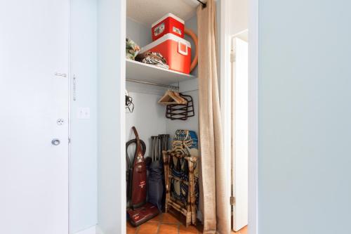 a hallway with a door open to a closet filled with shoes at Waikiki Place Studios at The Marine Surf Waikiki in Honolulu