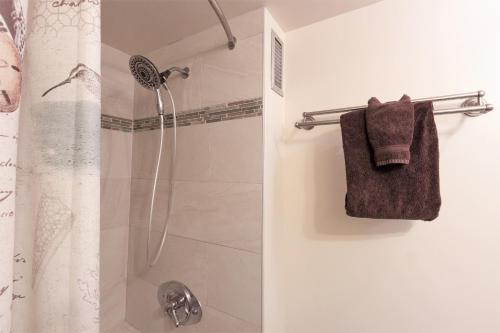 a bathroom with a shower curtain and a towel at Waikiki Place Studios at The Marine Surf Waikiki in Honolulu
