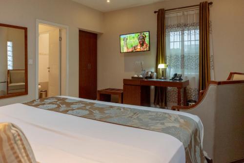 a hotel room with a bed and a window at Frederick's Lodge in Kumasi