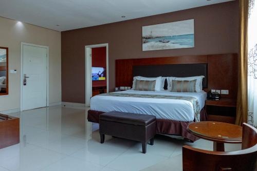 a bedroom with a large bed and a table at Frederick's Lodge in Kumasi
