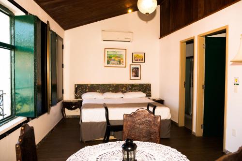a bedroom with two beds and a table and chairs at Pousada dos Quatro Cantos in Olinda