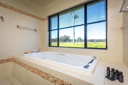 eine Badewanne im Bad mit Fenster in der Unterkunft Mandalay Villas - Villa 1 in Paxton
